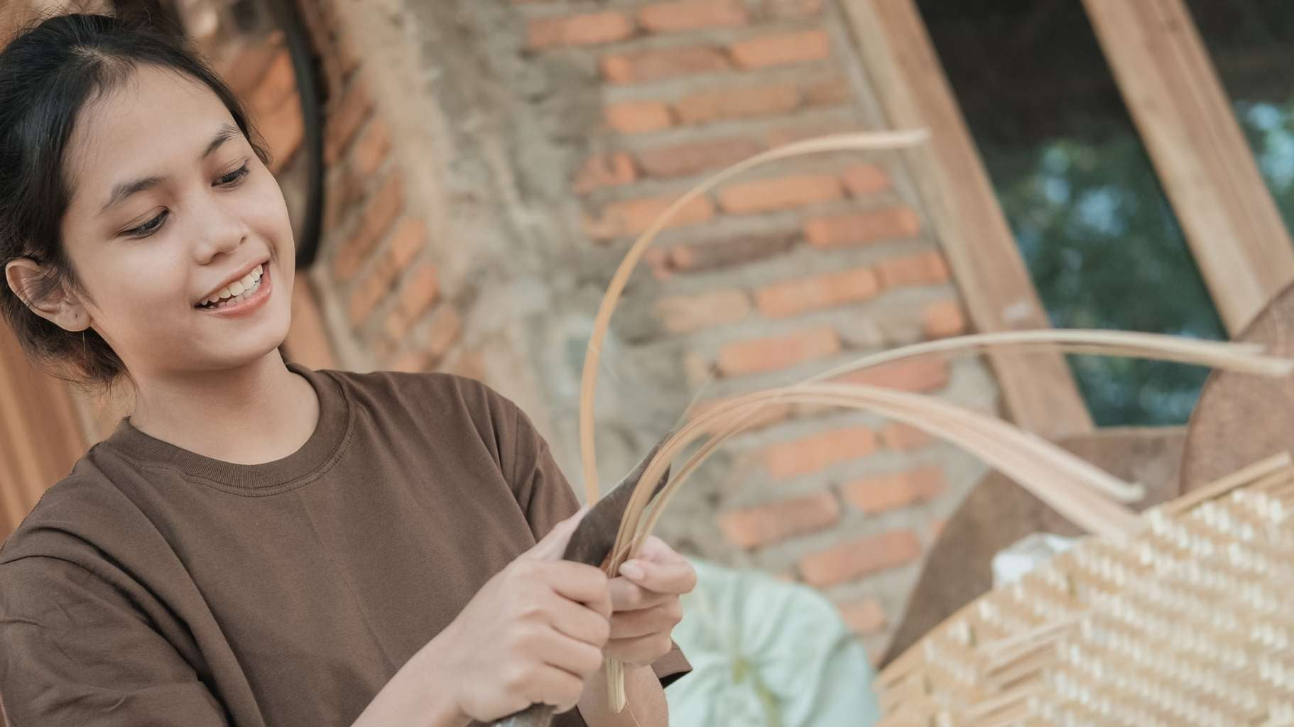 Woman working with woven materials in a rustic setting