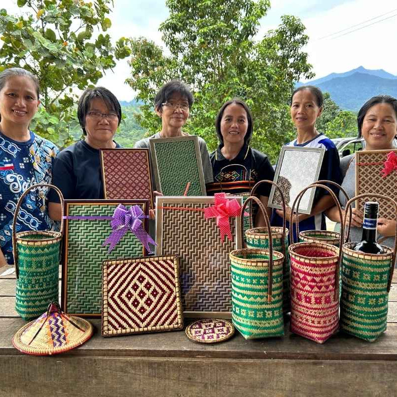 Group of women displaying their own handmade woven crafts.