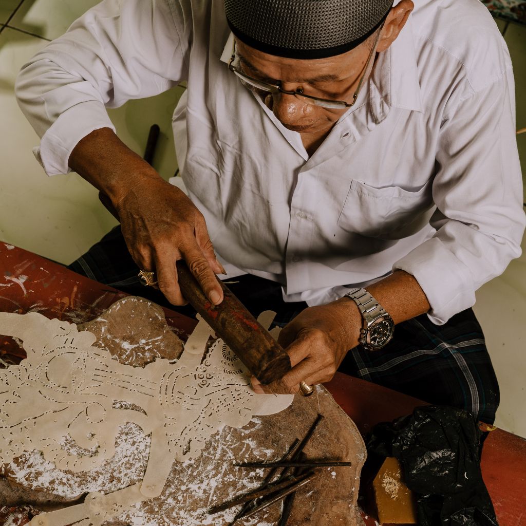 Rural elderly man doing crafts on table