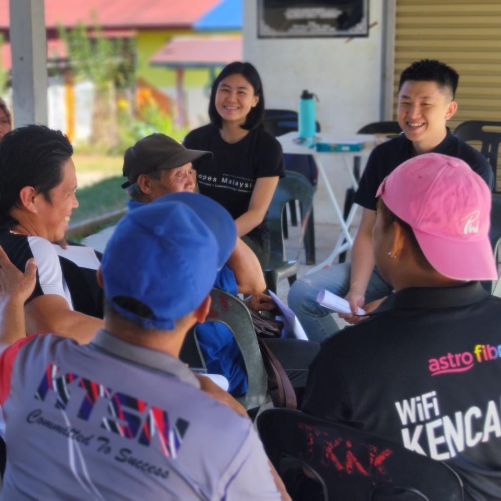 Hopes Malaysia team sitting outdoors, engaged in conversation with the rural communities to understand their struggles