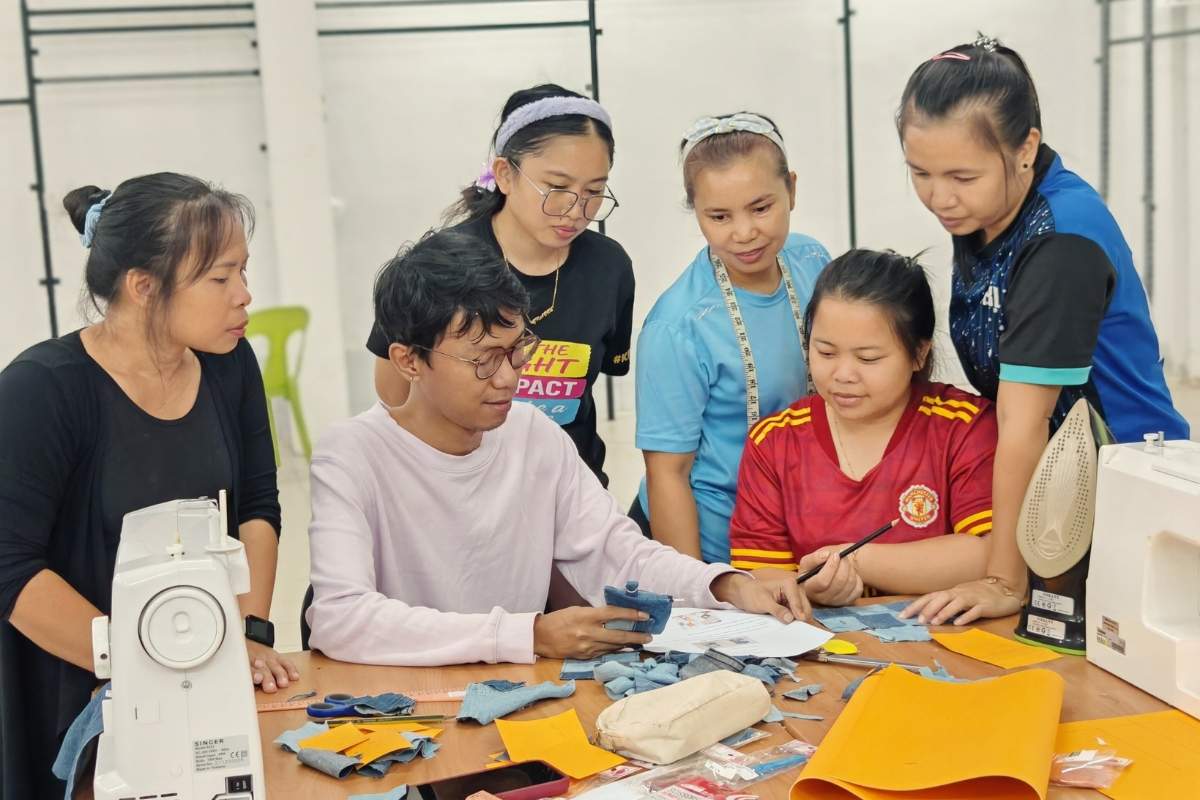 Group of rural women working together on a sewing project in a workshop led by an in house designer