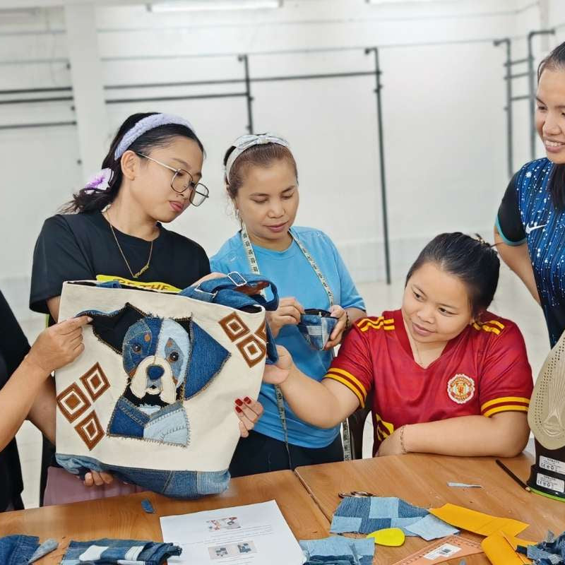 Group of rural women checking the product samples prepared by the designer before they start working on the products