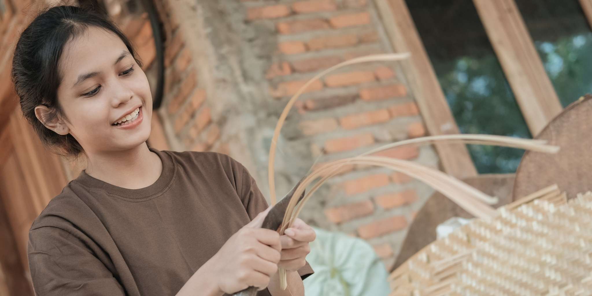 Woman working with woven materials in a rustic setting
