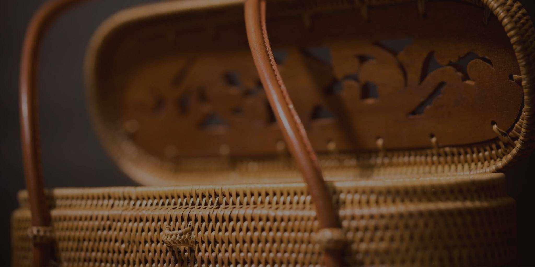 Close-up of a woven basket with decorative handles and cut-out patterns.