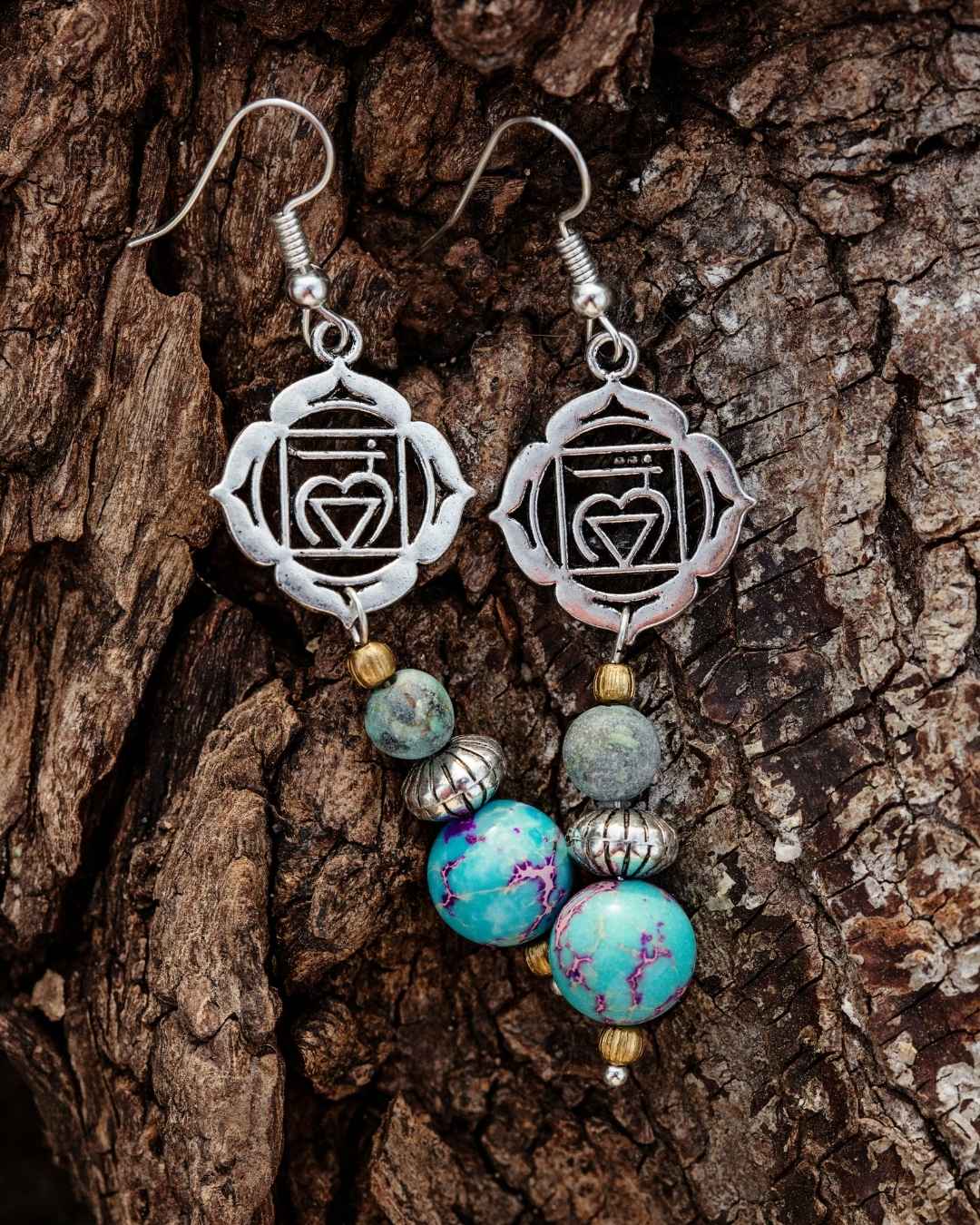 Pair of earrings with heart and circle design on a wooden surface