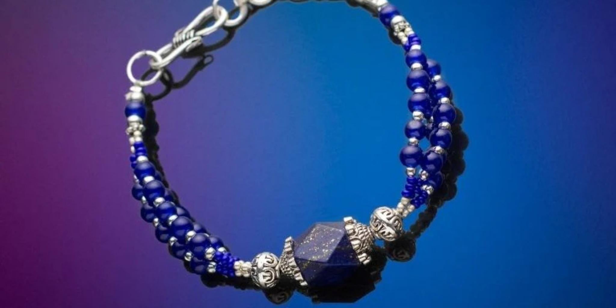 Bracelet with blue beads and silver clasp on a gradient background