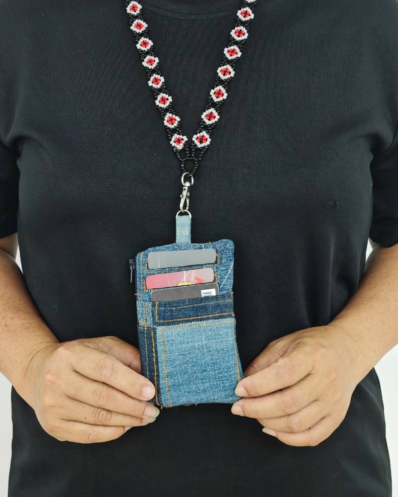 Close up of a handcrafted upcycled denim card holder paired with a traditional handmade necklace