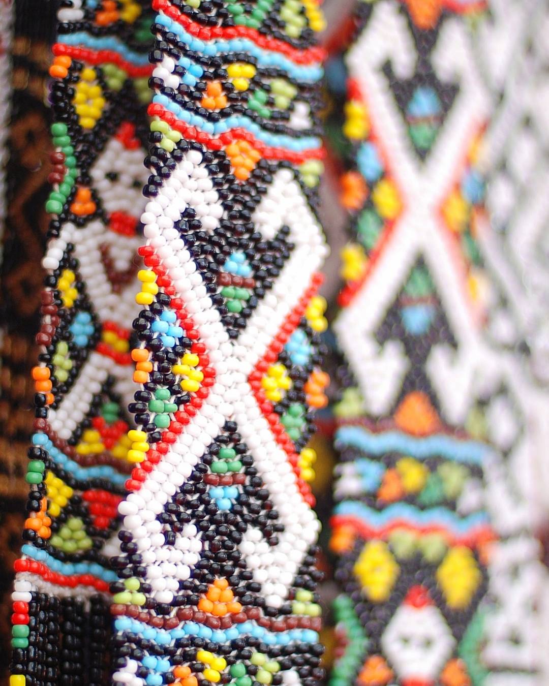 Close-up of a beaded necklace with geometric patterns in various colors.