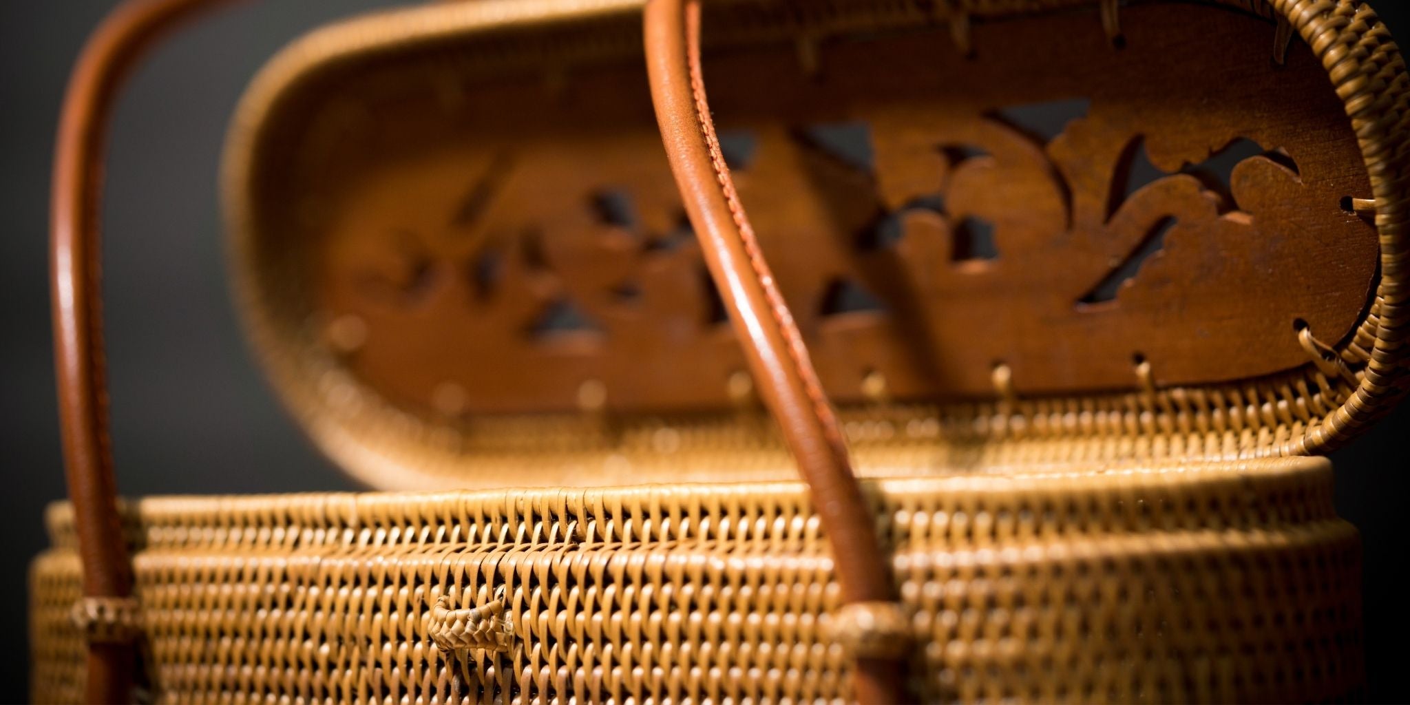 Close-up of a wicker picnic basket with decorative lid.