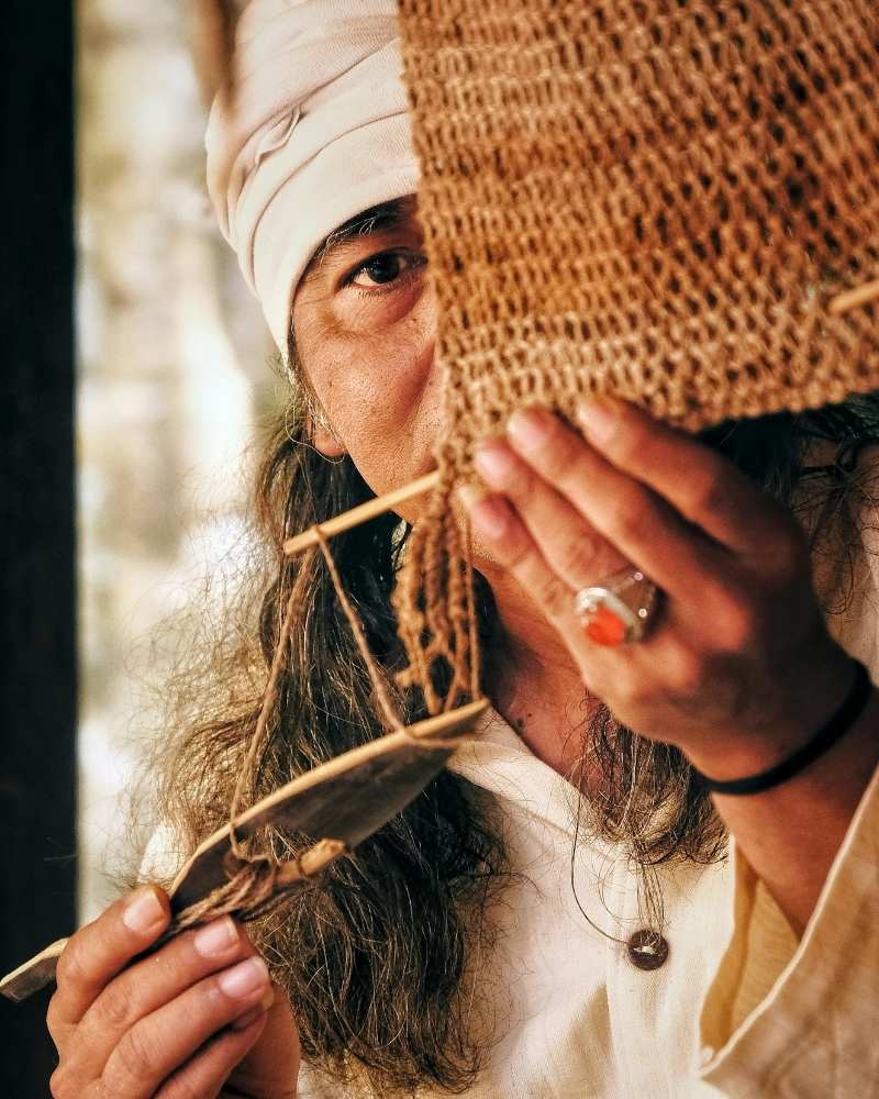 A man knitting a bag with a blurred background