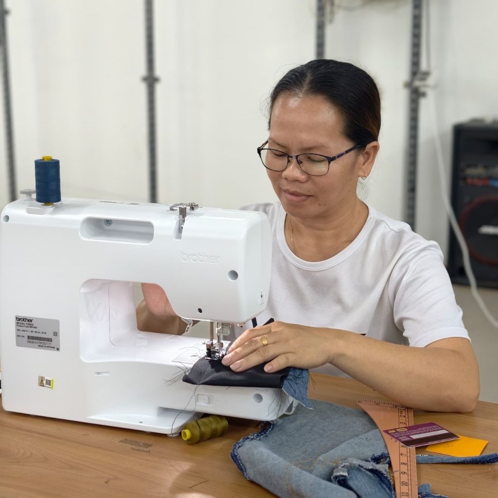 Rural woman sewing fabric pieces together to create handmade craft