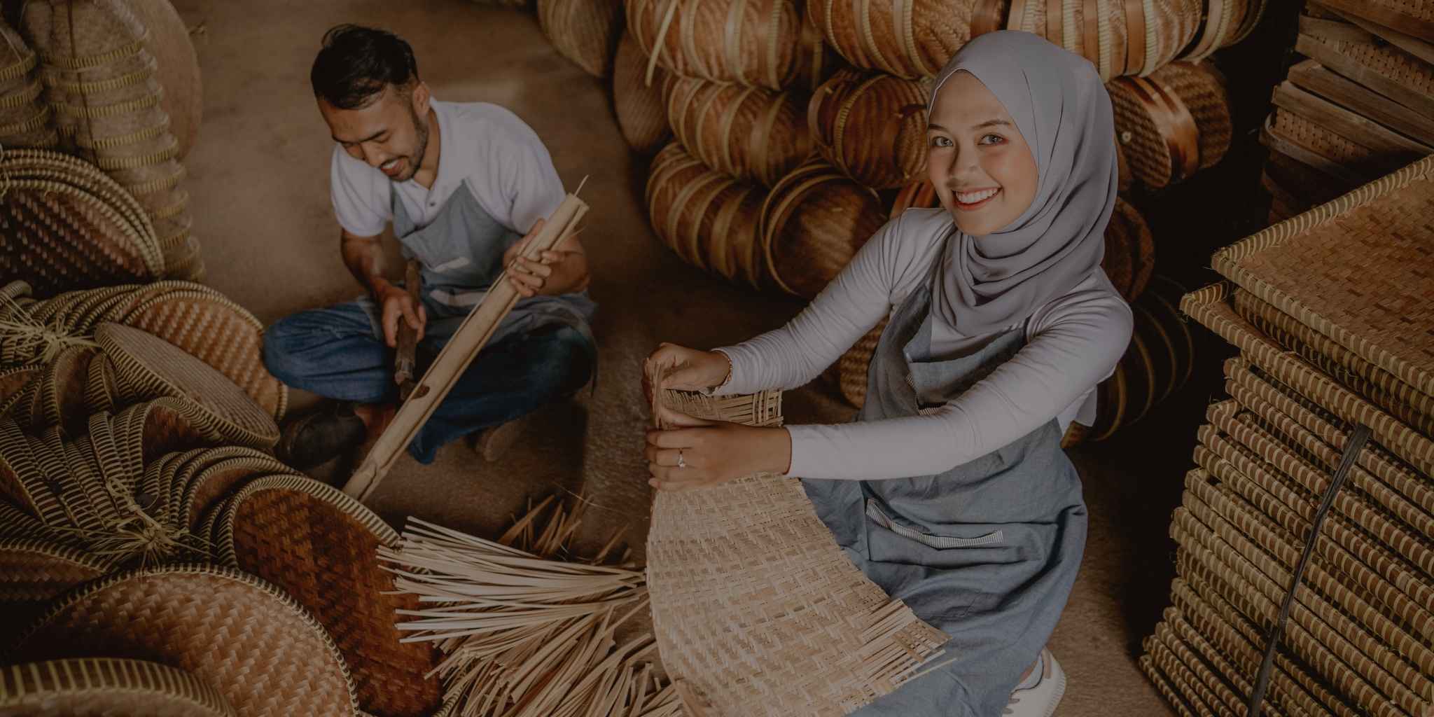 Two people working with woven baskets in a storage area.