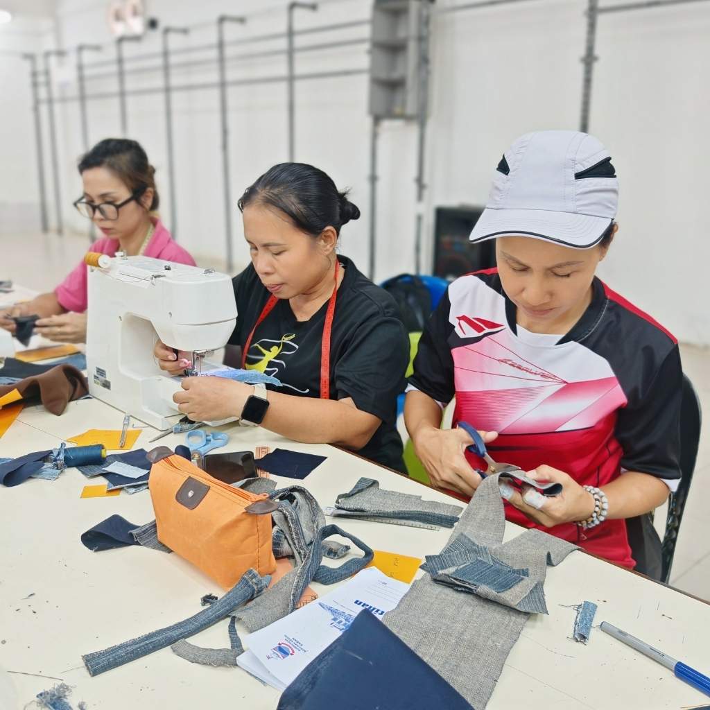 Three rural women working together to create handmade upcycled crafts using sustainable materials