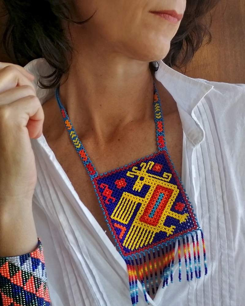 Colorful beaded necklace worn by a woman with a white shirt underneath