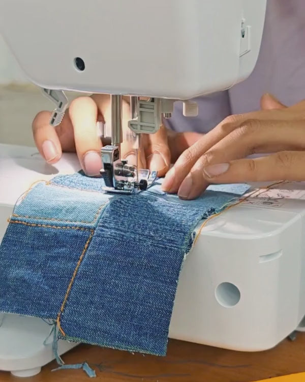 Close-up of artisan craftsmanship using a sewing machine to create handcrafted upcycled textile products
