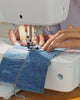 Close-up of artisan craftsmanship using a sewing machine to create handcrafted upcycled textile products