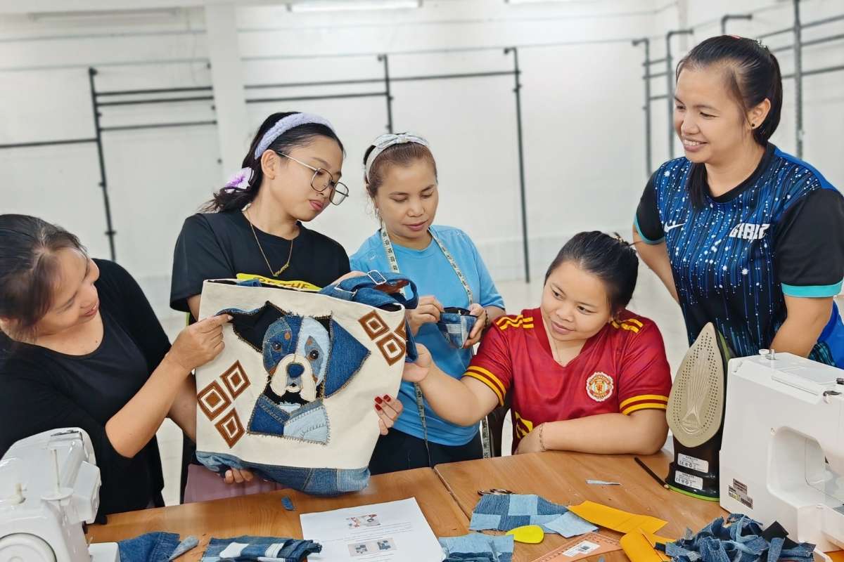 Group of rural women checking the product samples prepared by the designer before they start working on the products